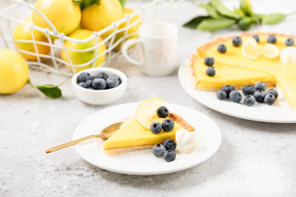 slice lemon pie with blueberries white plate 16750488893x2 tidXAE