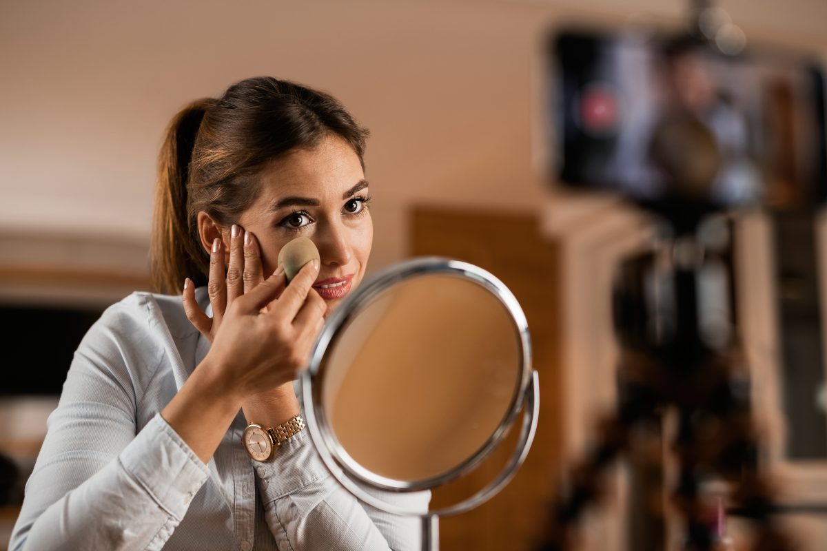 young influencer applying face powder while vlogging about makeup products from home 16770429823x2 DtqMiM