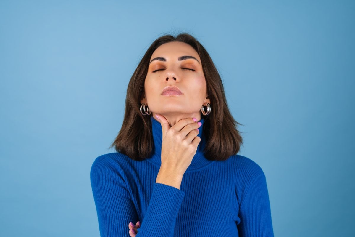young woman blue wall touches her throat suffers from pain 16773028343x2 cQn96b
