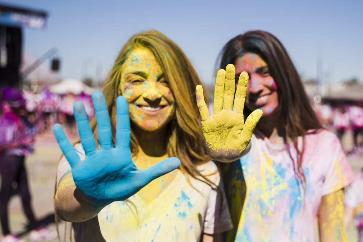 close up two young women showing their painted hands with holi color 16778592963x2 5qep1t