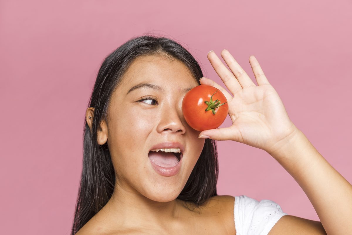 woman covering her eye with tomato 16778335603x2 3mUWS9